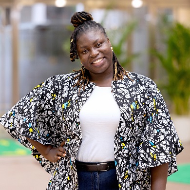 Al aire libre, una mujer con la mano apoyada en la cadera.