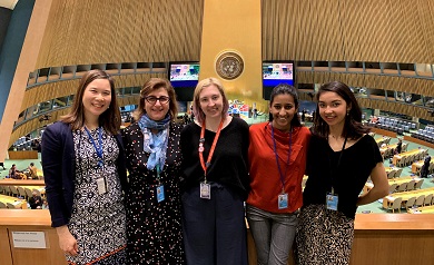 Five women in a row smiling at the camera