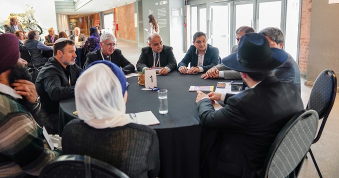 People from various religious backgrounds sitting around a table.