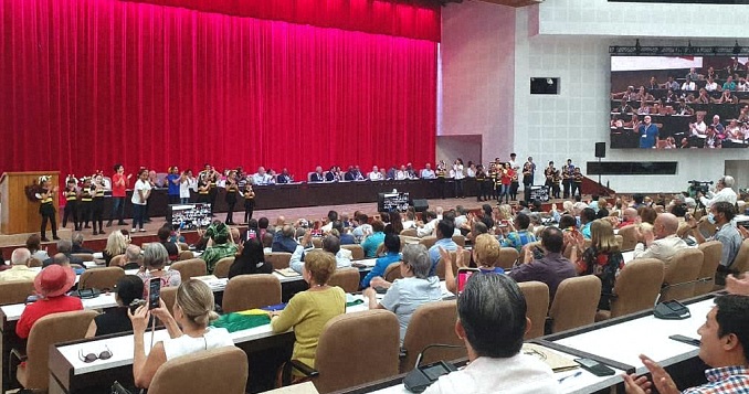 People in a large conference room facing a stage.