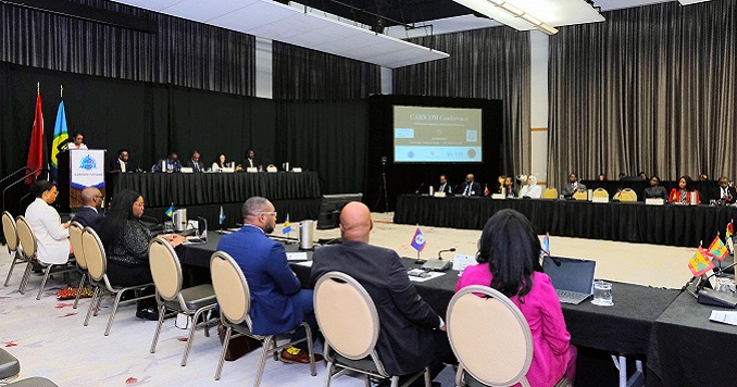 Participants of a conference seated around a table and listening to a presentation