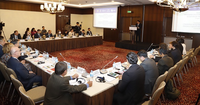 People seated around a table at a conference.