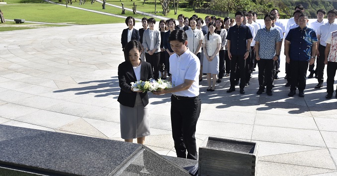 Two young people laying a wreath at a cornerstone of peace.