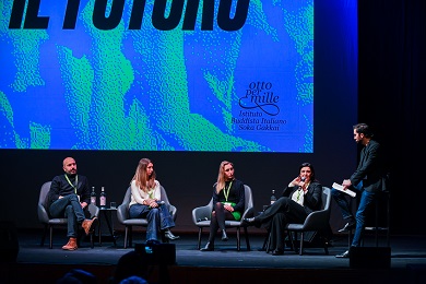 Five speakers seated on a stage