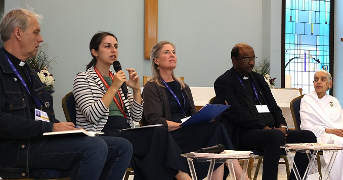 Five people of different faiths on stage during a panel discussion