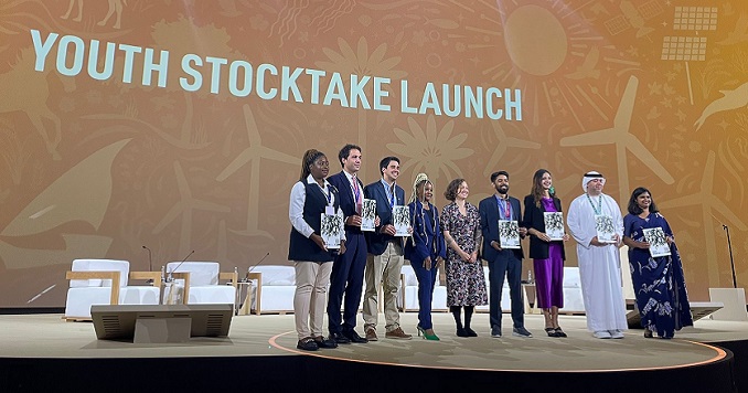 Young people standing on a stage posing for a group photo.