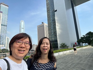 Two women posing for a photo together outside