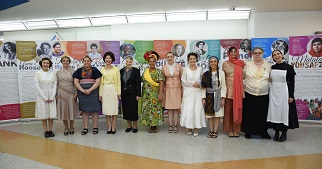 Diverse women in front of exhibition panels.
