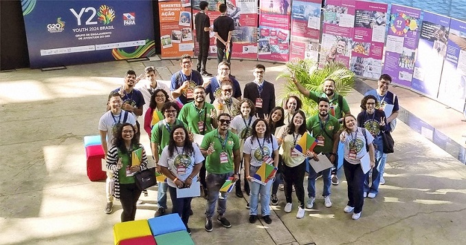 A group of young people posing for a commemorative photo in front of exhibition panels.
