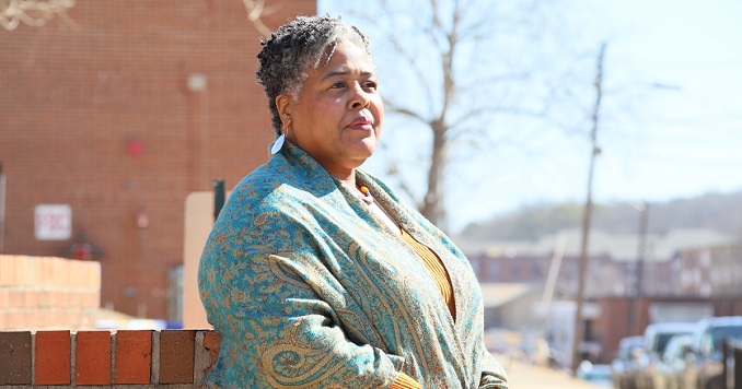 A woman standing outside on a sunny day.
