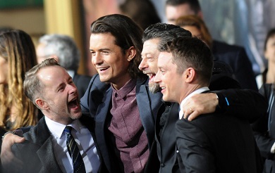 Orlando Bloom celebrating with fellow actors at the premier of The Hobbit.