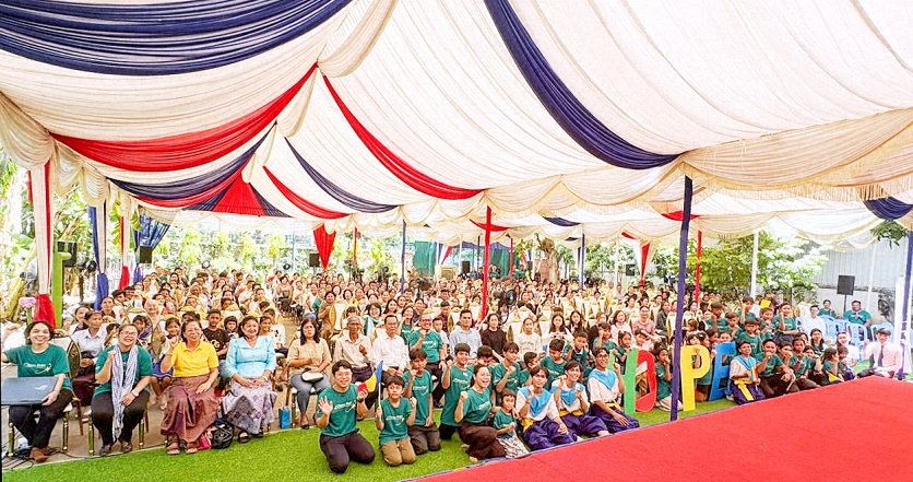 People seated under a large outdoor canopy for a youth culture festival.