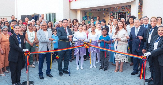 People outside a new building at a ribbon cutting ceremony.