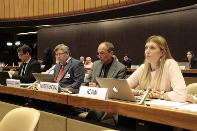 Close up of three men and Ms. Fihn seated at a conference table