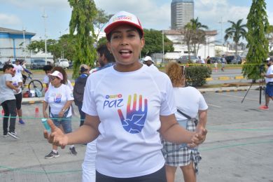 An outdoor shot of a woman with event participants in the background