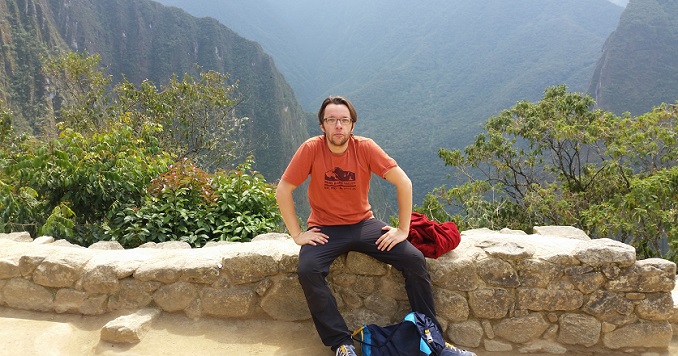 Photo of Nicolas Boutin sitting on a rock wall